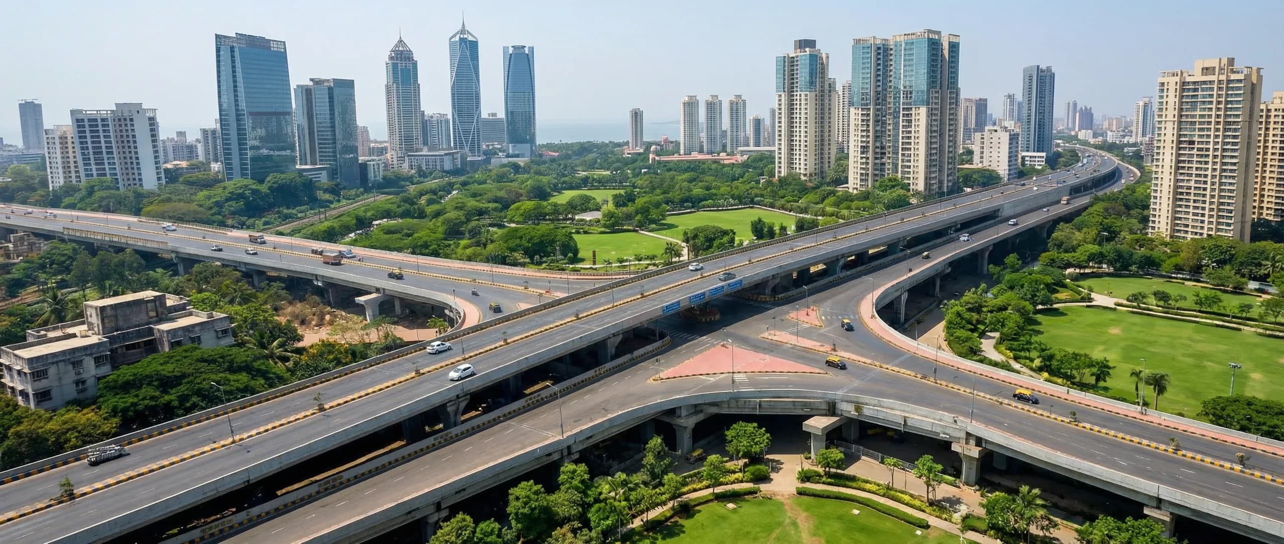 Aerial view of the Eastern Freeway interchange at Chembur, with the Bombay Presidency Golf Club greens and the Mumbai skyline beyond